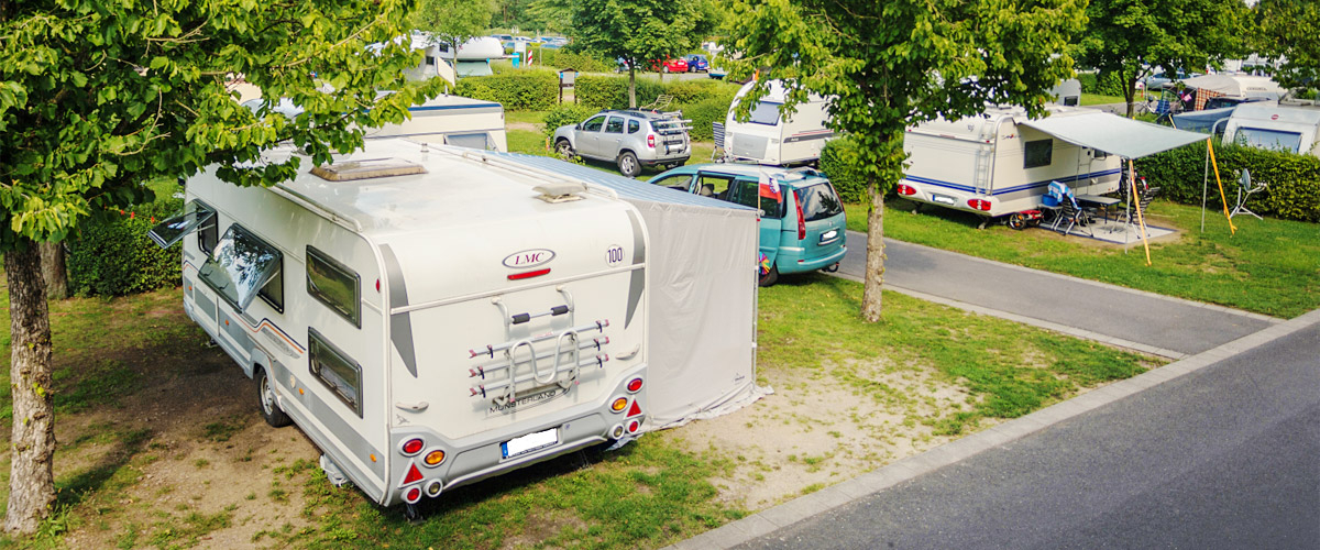 Begrünte Parzellen-Stellplatzanlage mit Wohnwagen und Wohnmobilen.