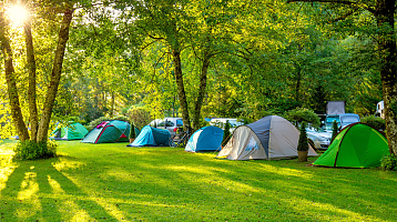 zelená plocha s několika místy pro stany