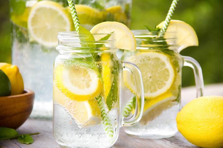 Two refreshing drinks with lemon slices and mint leaves.