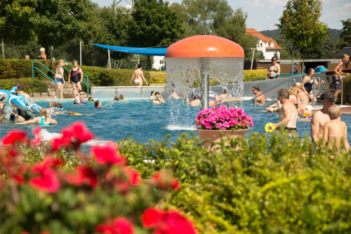 busy swimming pool with bathers