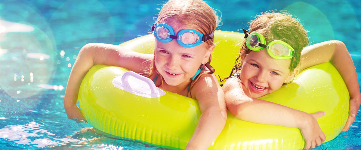 two happy children with swimming rings in the water