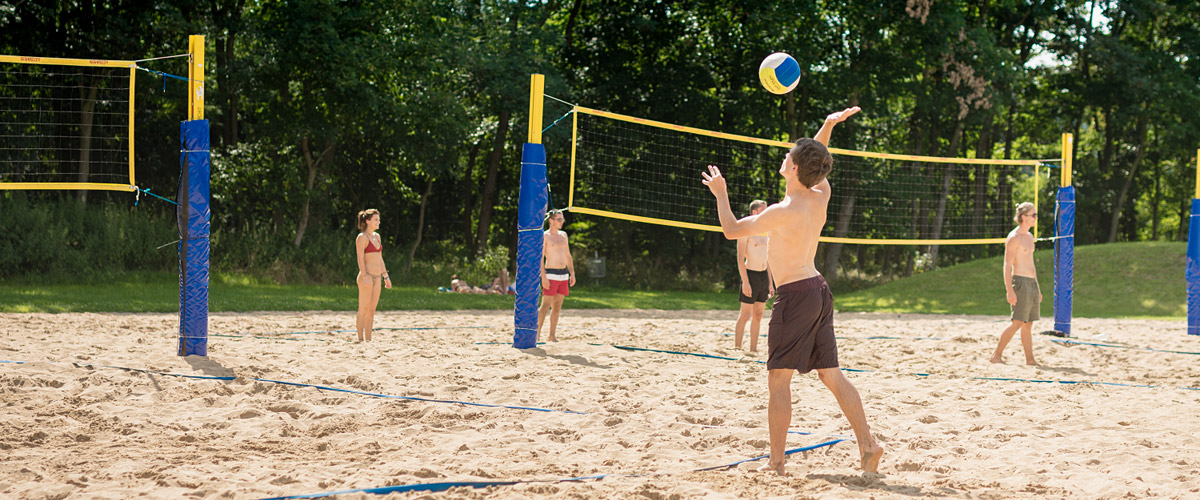 sportliche Badegäste beim Beachvolleyball-Spiel
